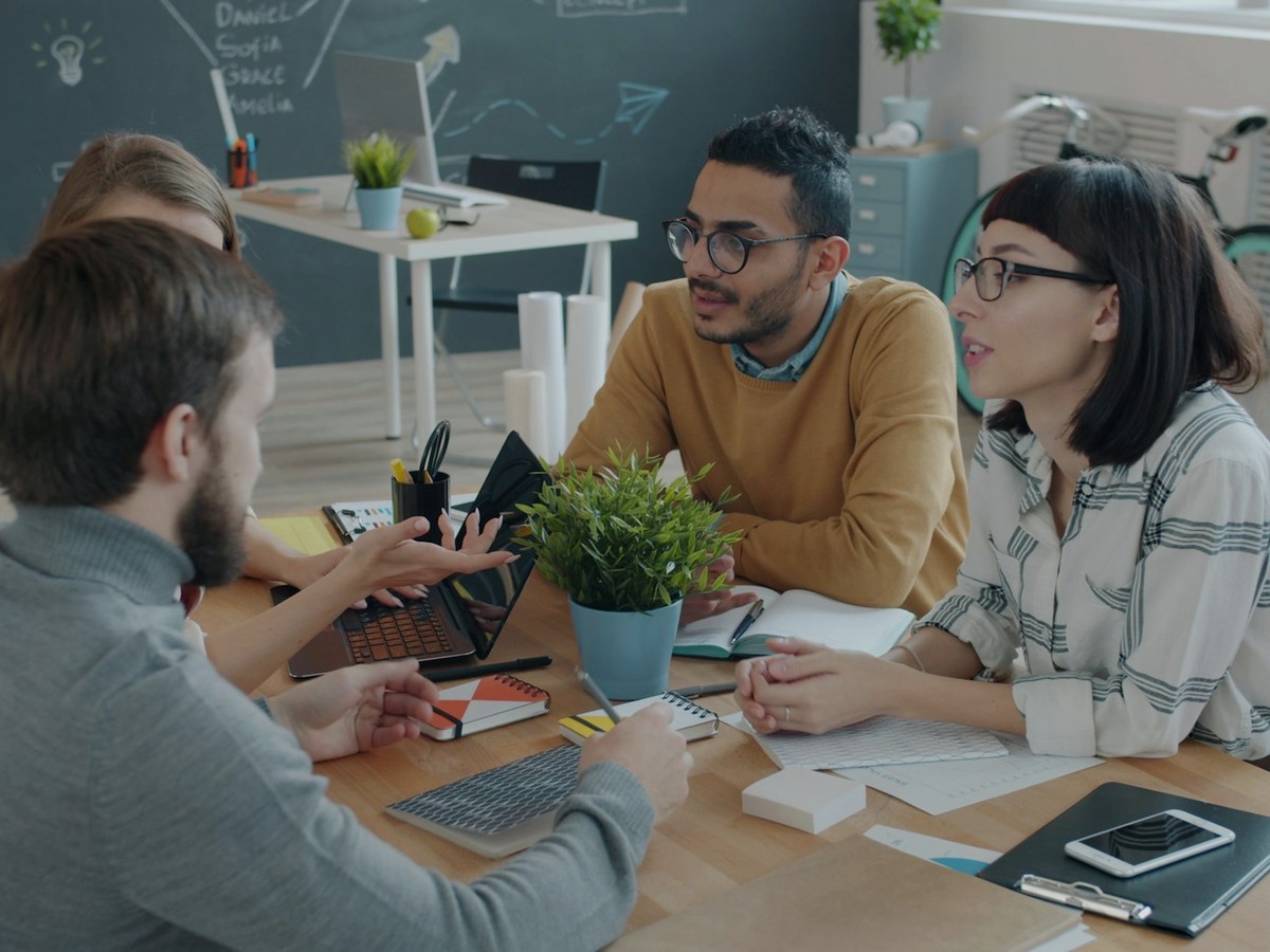 Équipe en co-développement autour d’une table, échange sur un projet terrain.